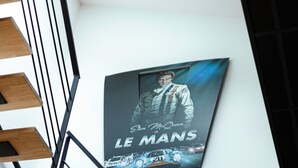 A staircase with a poster on the wall.