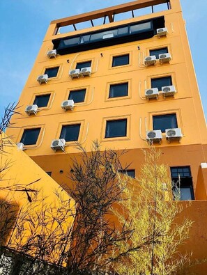 Ein mehrgeschossiges Gebäude, an jedem Fenster sind Klimaanlagen angebracht.
