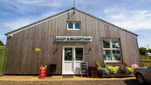 Un bâtiment en bois avec une enseigne indiquant « MAGASIN ET RÉCEPTION ».