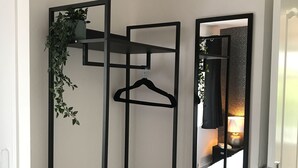 A compact room with a black metal wardrobe, a mirror, and a small bench. - Modern 3-bed House With Parking Bamber Bridge, Preston (Preston)