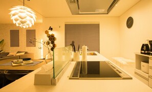 A modern kitchen with a central island, a dining area with a sofa, and a living room with a couch.