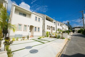 Stylish building with a flat roof and large windows, set amidst a well-manicured lawn.
