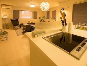 Relax and unwind in this stylish living area, featuring a flat-screen TV, comfortable seating, and a fully equipped kitchen.