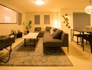 Relax in this inviting living space with a comfortable sofa, dining table, and large flat-screen TV.