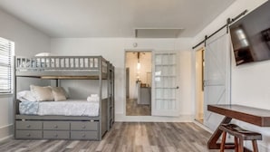 Een slaapkamer met een stapelbed, een bureau en een stoel.