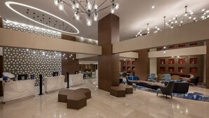 A spacious lobby with a reception desk, seating areas, and decorative lighting. - The Superior Living Batisehir  (Istanbul)