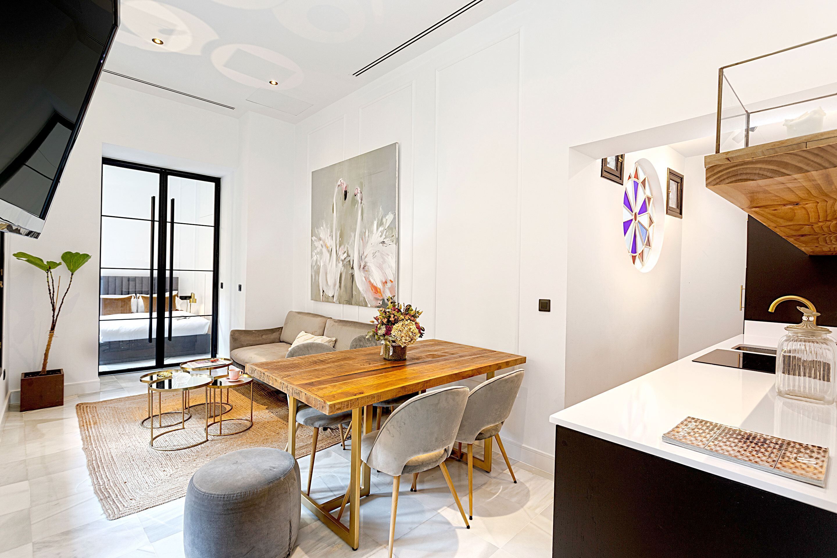 Una cocina moderna con una mesa de comedor de madera, sillas grises y una encimera blanca.