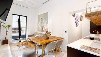 Una cocina moderna con una mesa de comedor de madera, sillas grises y una encimera blanca.