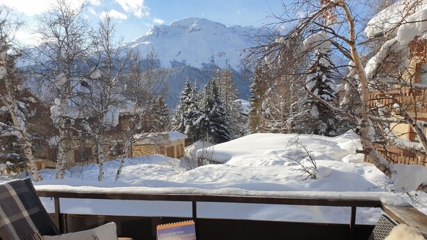 A balcony with a table set for breakfast, overlooking a snowy mountain landscape. - 3-room apartment on the first floor, 67m2. (Celerina/Schlarigna)