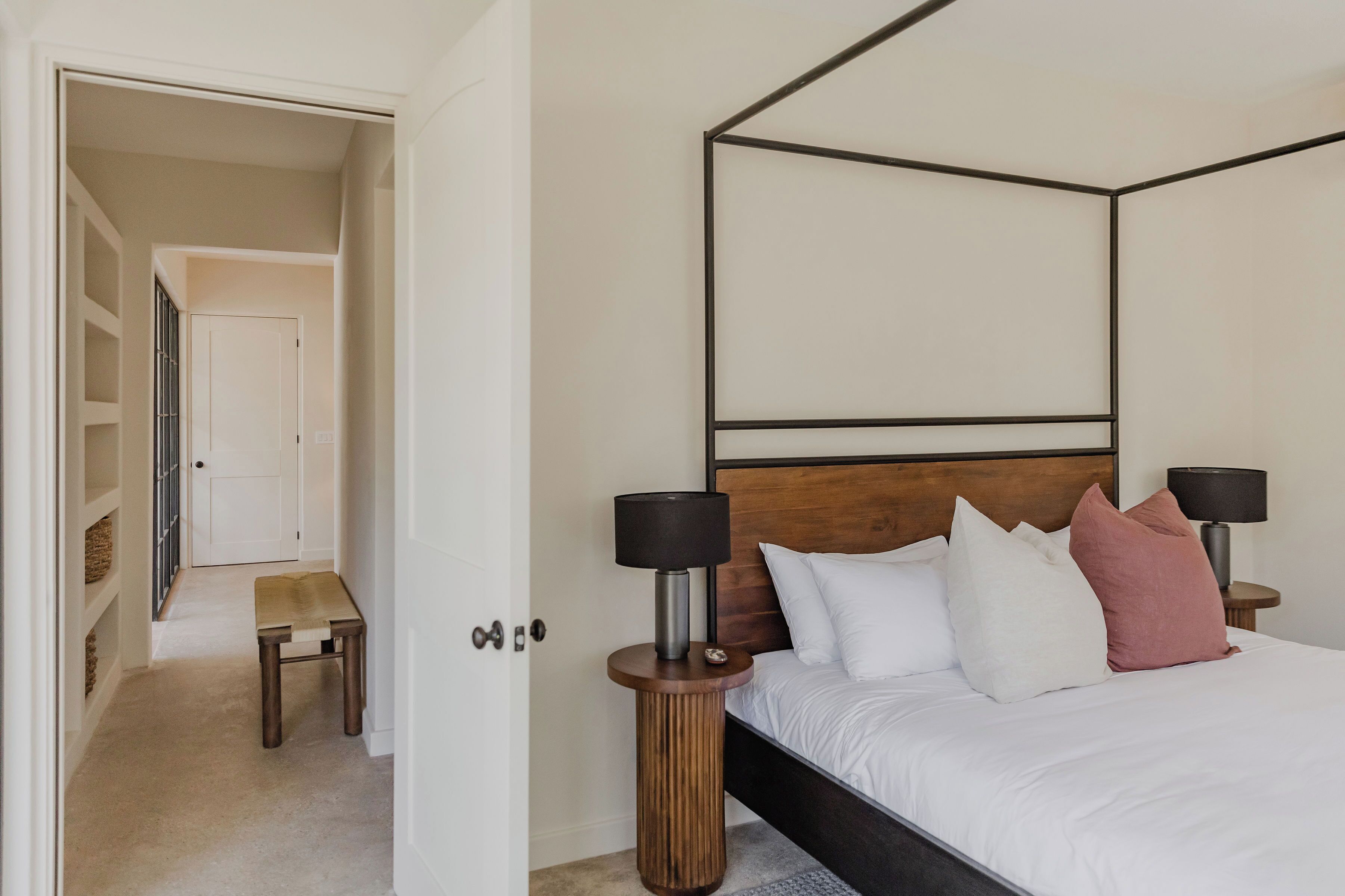 Une chambre à coucher avec un lit à baldaquin, des lampes de chevet et une tête de lit en bois.