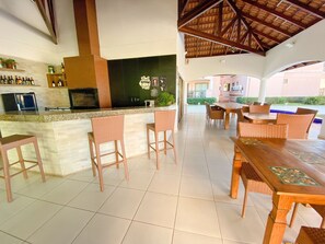 A bar area with a counter, bar stools, and a view of the outdoor seating area.