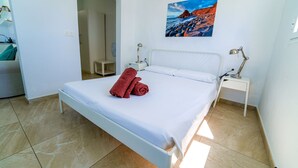 A bedroom with a bed, a painting, and a nightstand. - One bedroom apartment with pool views (TAHICHE)