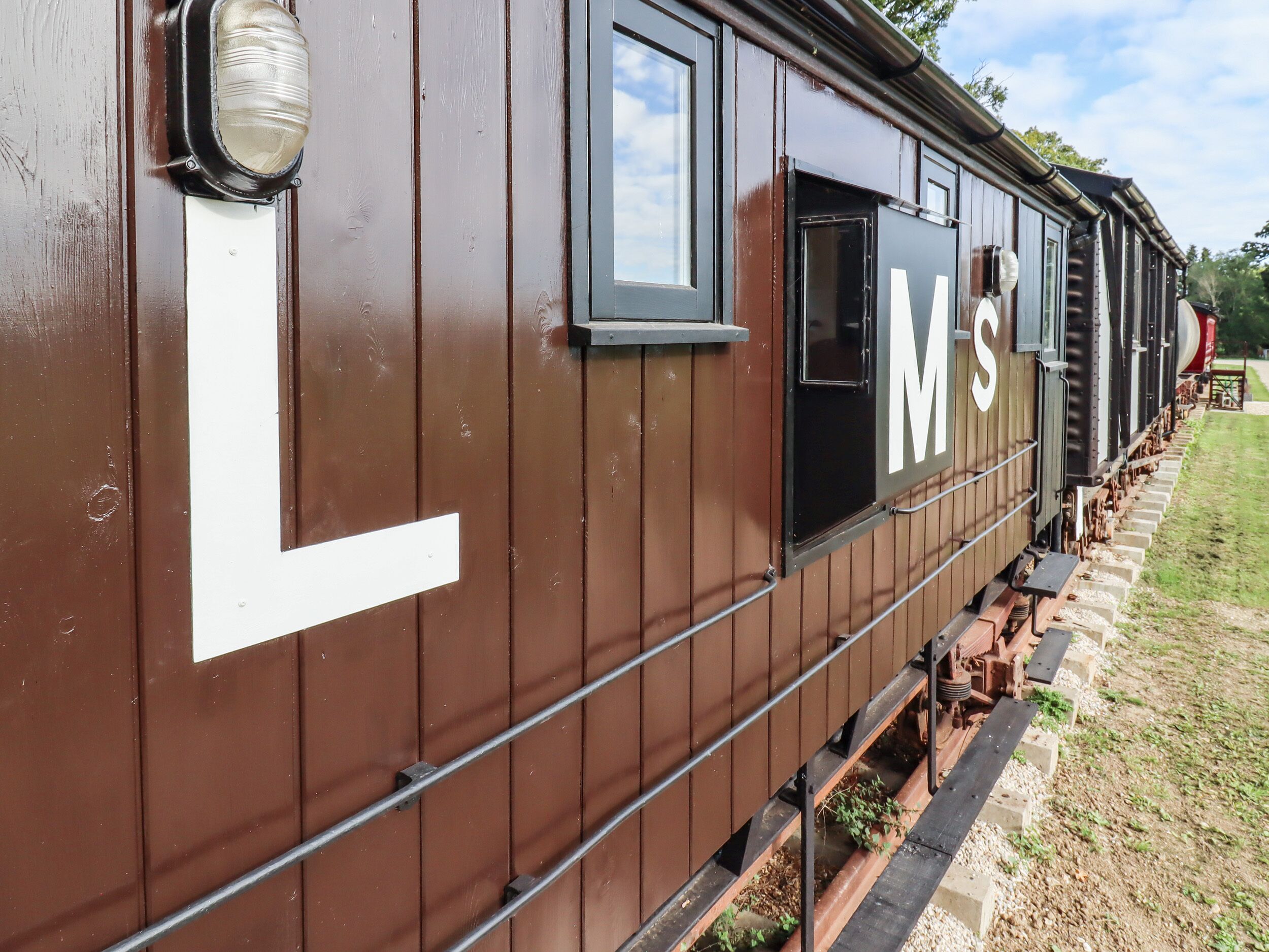 A brown train car with the letters "L" and "MS" on its side.
