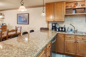 A kitchen with granite countertops, wooden cabinets, a coffee maker, and a toaster. - 2BR Condo w/ Amazing Locale, Minutes from Slopes! (Park City)