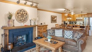 Ein Wohnzimmer mit Kamin, einer Couch, einem Couchtisch und einem gemusterten Teppich.