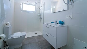 A modern bathroom with a toilet, sink, and shower. - Two bedroom apartment with double beds (TAHICHE)