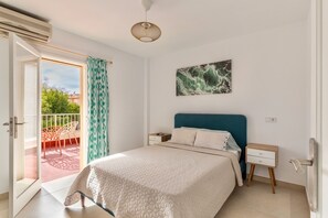 A bedroom with a bed, a nightstand, a wall-mounted artwork, a ceiling light, and a sliding glass door leading to an outdoor area. - Vacation Home 'Villa Santa Lucia' with Private Pool, Terraces and Wi-Fi (Calvia)