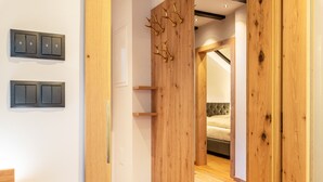 Una habitación moderna con paneles de madera, un espejo, una cama y dos interruptores de luz en la pared.