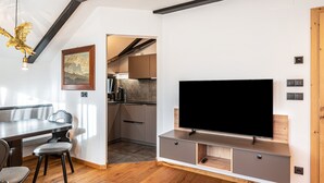 Un espacio moderno para vivir con comedor, cocina y mueble de entretenimiento.