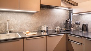 A modern kitchen with a stainless steel sink, two pots, a coffee maker, and a kettle. - Apartment 'Residence Skutial - Schlern' with Mountain View, Balconies & Wi-Fi (Castelrotto)