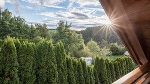 A view from a window overlooking a forested landscape with a clear sky. - Apartment 'Residence Skutial - Schlern' with Mountain View, Balconies & Wi-Fi (Castelrotto)