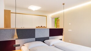 Une chambre moderne avec un lit, une table de chevet et une tête de lit à motifs à carreaux.