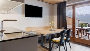 A modern kitchen with a built-in sink and a flat-screen TV mounted on the wall. - Apartment "Angerle Alm Apt Similde A" with Private Terrace, Shared Garden & Wi-Fi (carezza Nova Levante)