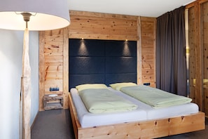A wooden bed with a headboard, two pillows, and a blanket. - Apartment "Angerle Alm Apt Similde B" with Private Terrace, Shared Garden & Wi-Fi (carezza Nova Levante)