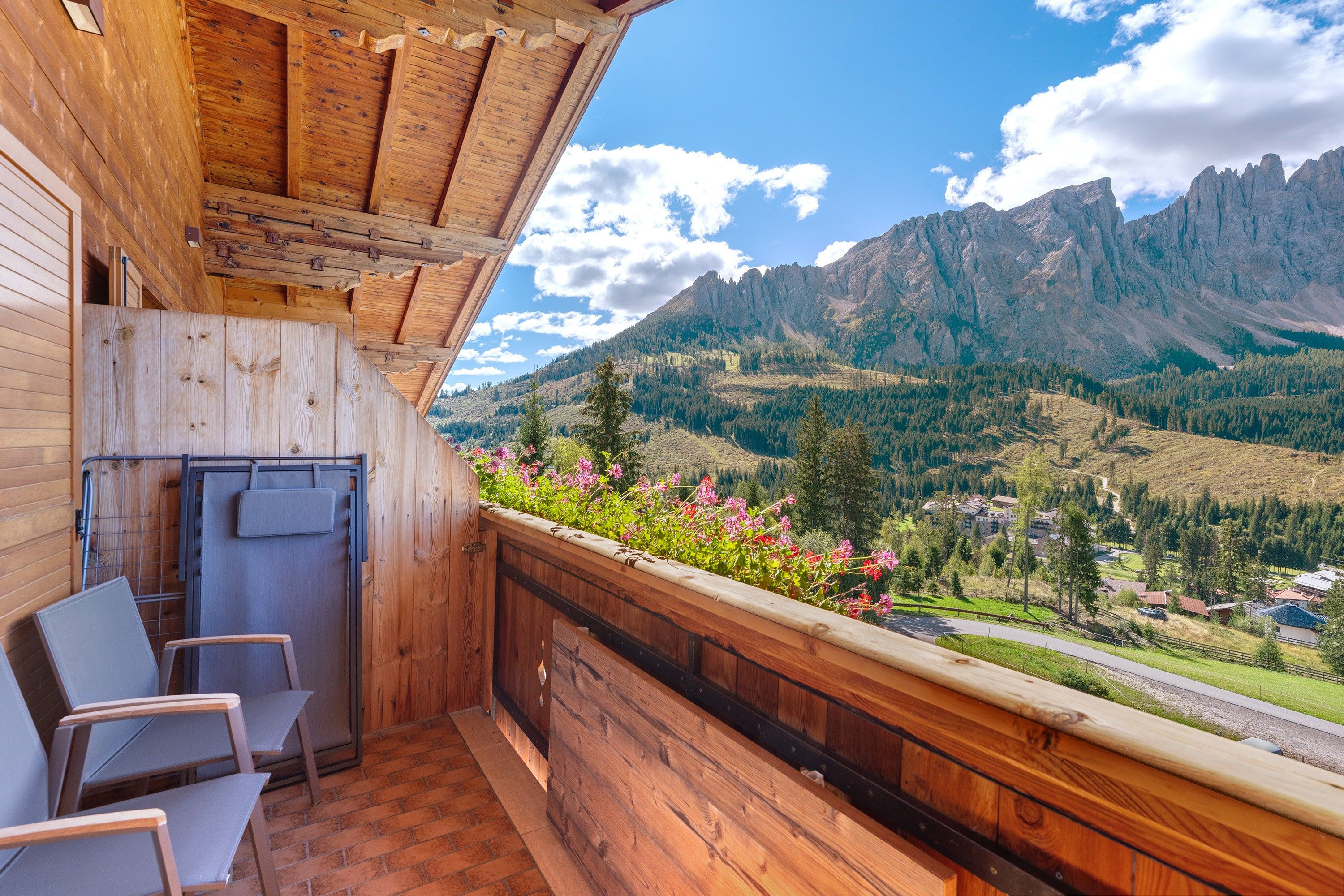 Un balcon en bois offrant une vue sur un paysage montagneux.