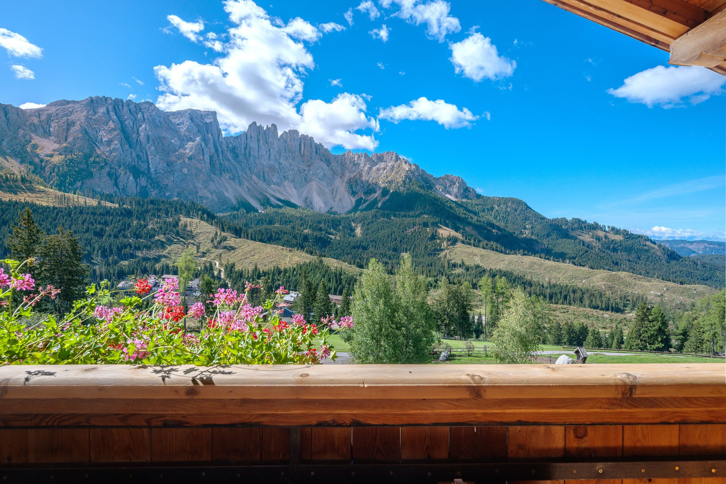 Eine Berglandschaft mit einer Holzterrasse mit Blick auf ein Tal.