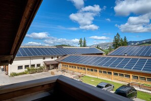 A building with solar panels on the roof and a view of mountains in the background. - Apartment "Angerle Alm Apt Rosengarten" with Private Balcony, Shared Garden and Wi-Fi (carezza Nova Levante)
