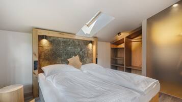 Une chambre à coucher moderne avec un puits de lumière, une tête de lit en bois et des étagères intégrées.
