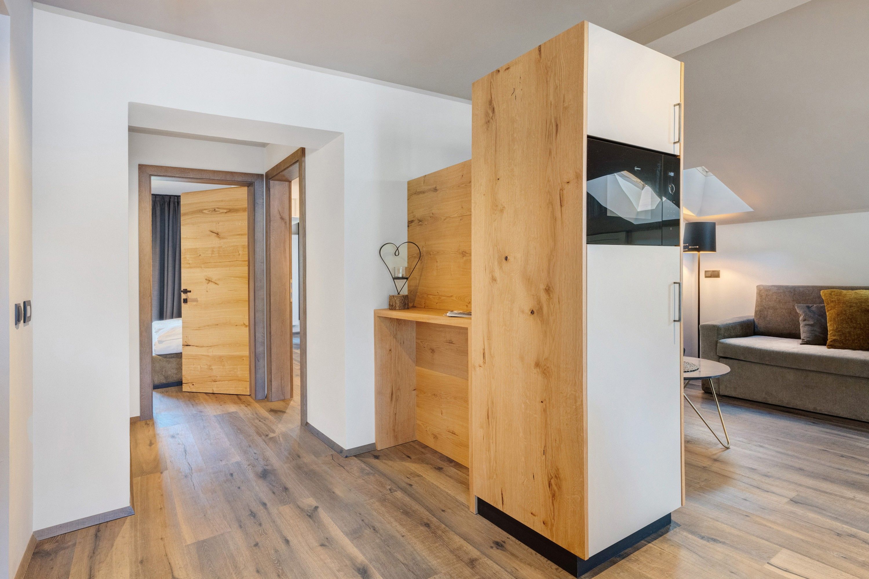 Un salon moderne avec un mur d’accent en bois, un canapé et une lampe.
