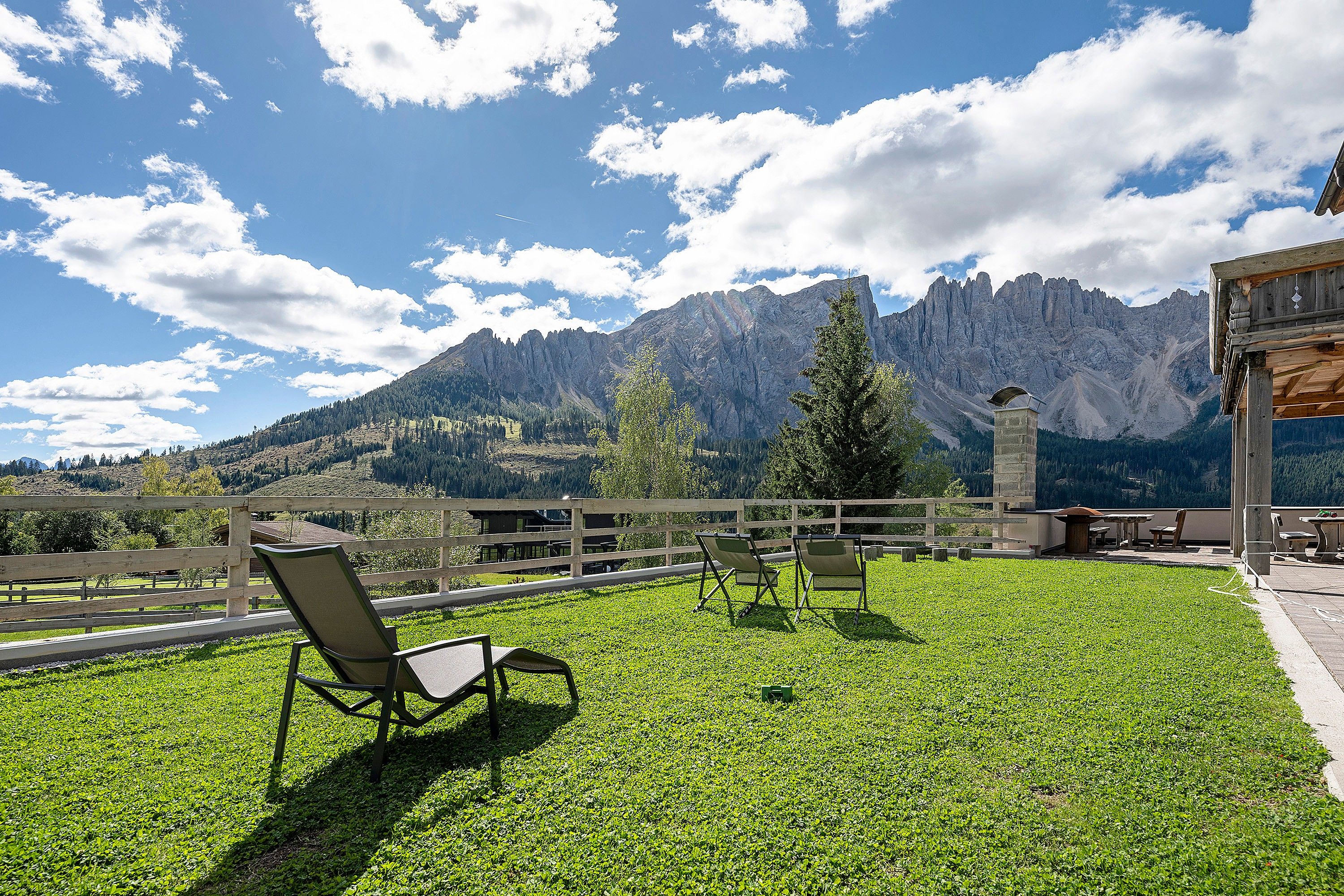 Una terrazza con sedie e tavoli, con vista su un paesaggio montuoso.