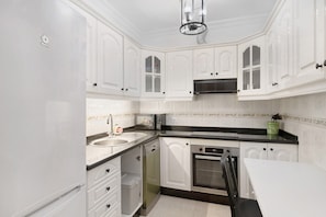 A kitchen with white cabinetry, a dishwasher, an oven, and a microwave. - Vacation Home 'Alpispa' with Balconies & Wi-Fi (Arrecife)