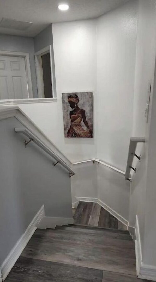 A staircase with wooden steps and white walls, leading to an upper floor. - The Oaks Bay (Kissimmee)