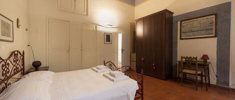 A bedroom with a bed, wardrobe, desk, and chair.
