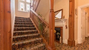 Eine prächtige Treppe mit aufwendiger Holzgalerie und Teppichstufen.