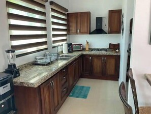 Kitchen equipped with a gas stove, microwave, coffee maker, and sink.