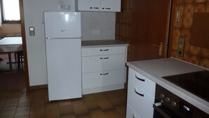 Una cocina compacta con refrigerador, estufa y encimera.