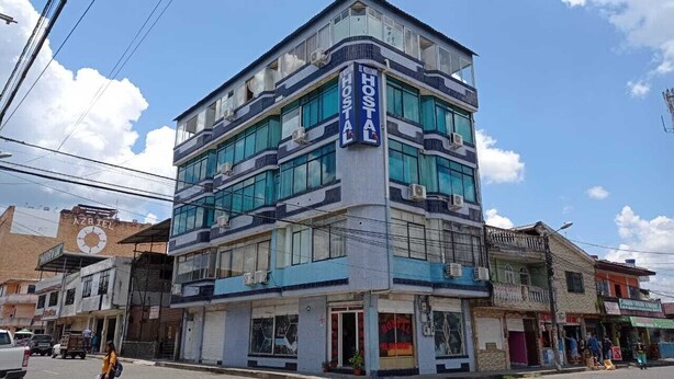 A multi-story building with a prominent 'HOSTAL' sign, featuring a modern design with large windows and a flat roof. - HOSTAL MIRADOR (Coca)