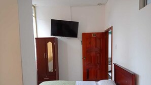 A bedroom with a bed, a wardrobe, a television mounted on the wall, and a door with the number 08. - HOSTAL MIRADOR (Coca)