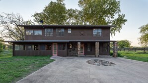 A two-story building with a stone facade, large windows, and a prominent star symbol. - Authentic Ranch Home on 650 Acres with Peace and Tranquility (Marble Falls)