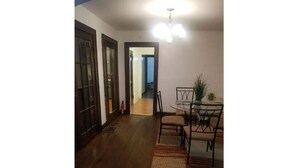 A dining area with a table and chairs, a chandelier, and a plant. - Cozy Emerson Heights Bungalow (Indianapolis)