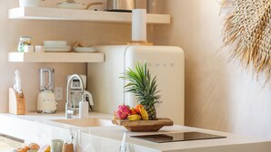 Una cocina moderna con armarios blancos, una isla integrada y diversos electrodomésticos.