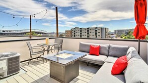A rooftop terrace with outdoor seating, a table, and a view of the cityscape. - City Skyline Views: Upscale Denver Townhome (Denver)