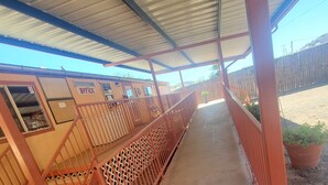 A covered outdoor area with a metal roof, a wooden fence, and a concrete floor. - Rode Inn of Clifton (Clifton)
