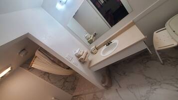 A bathroom with a toilet, sink, and a mirror.