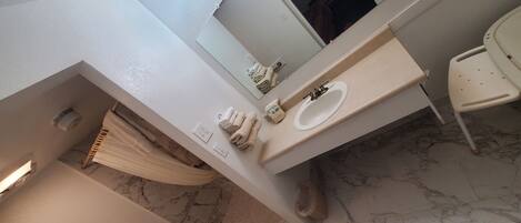 A bathroom with a toilet, sink, and a mirror.