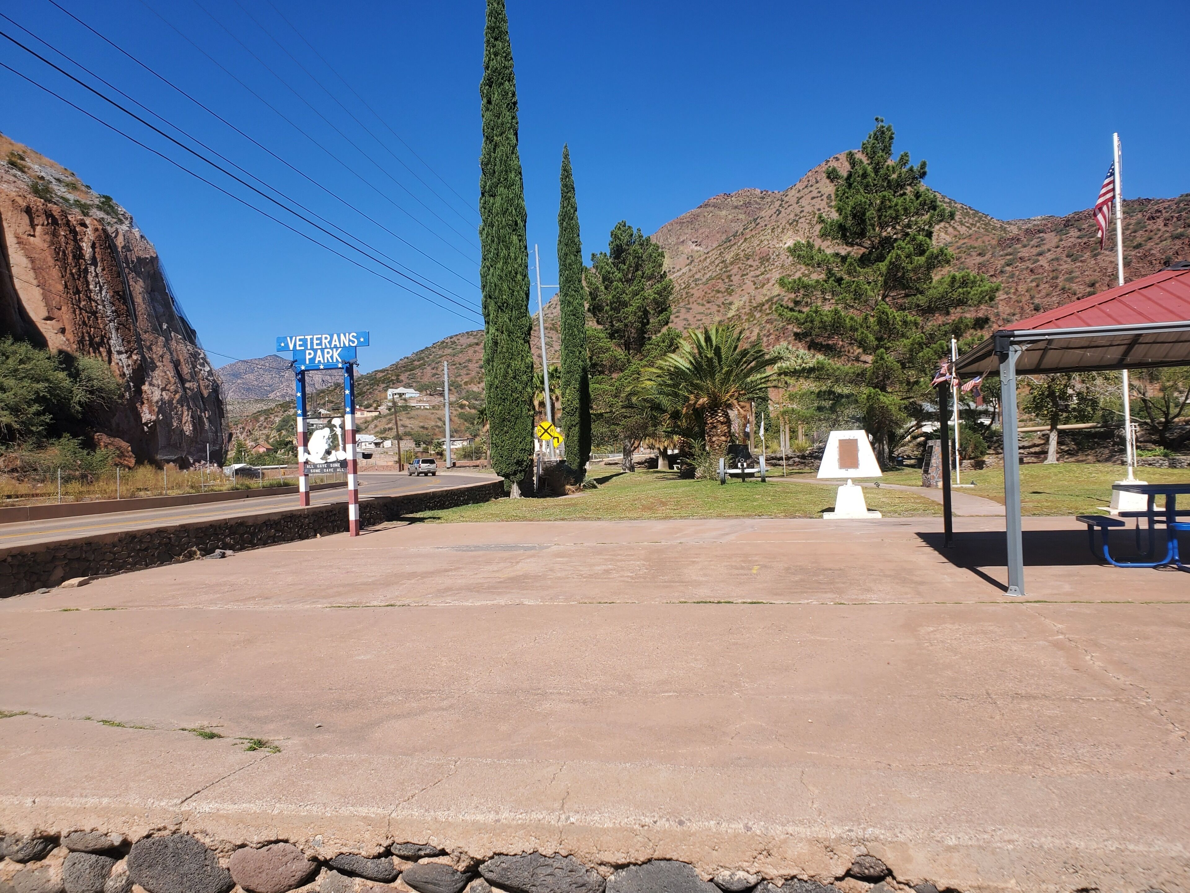 A Veterans Park with a picnic area, a bench, and a small shelter.